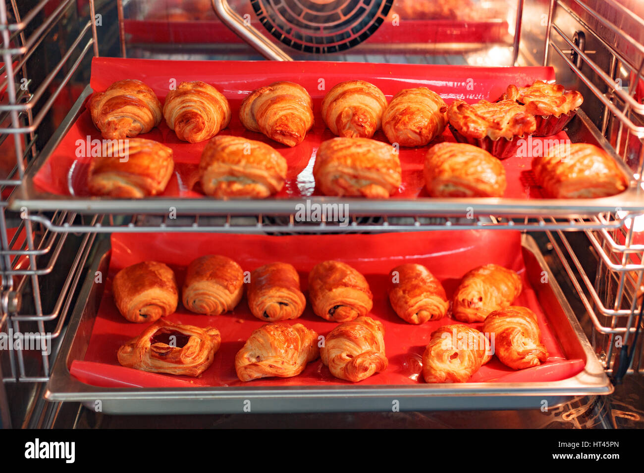 Butter-Backen im offenen professionelle Ofen auf die rote Silikonhülle Stockfoto