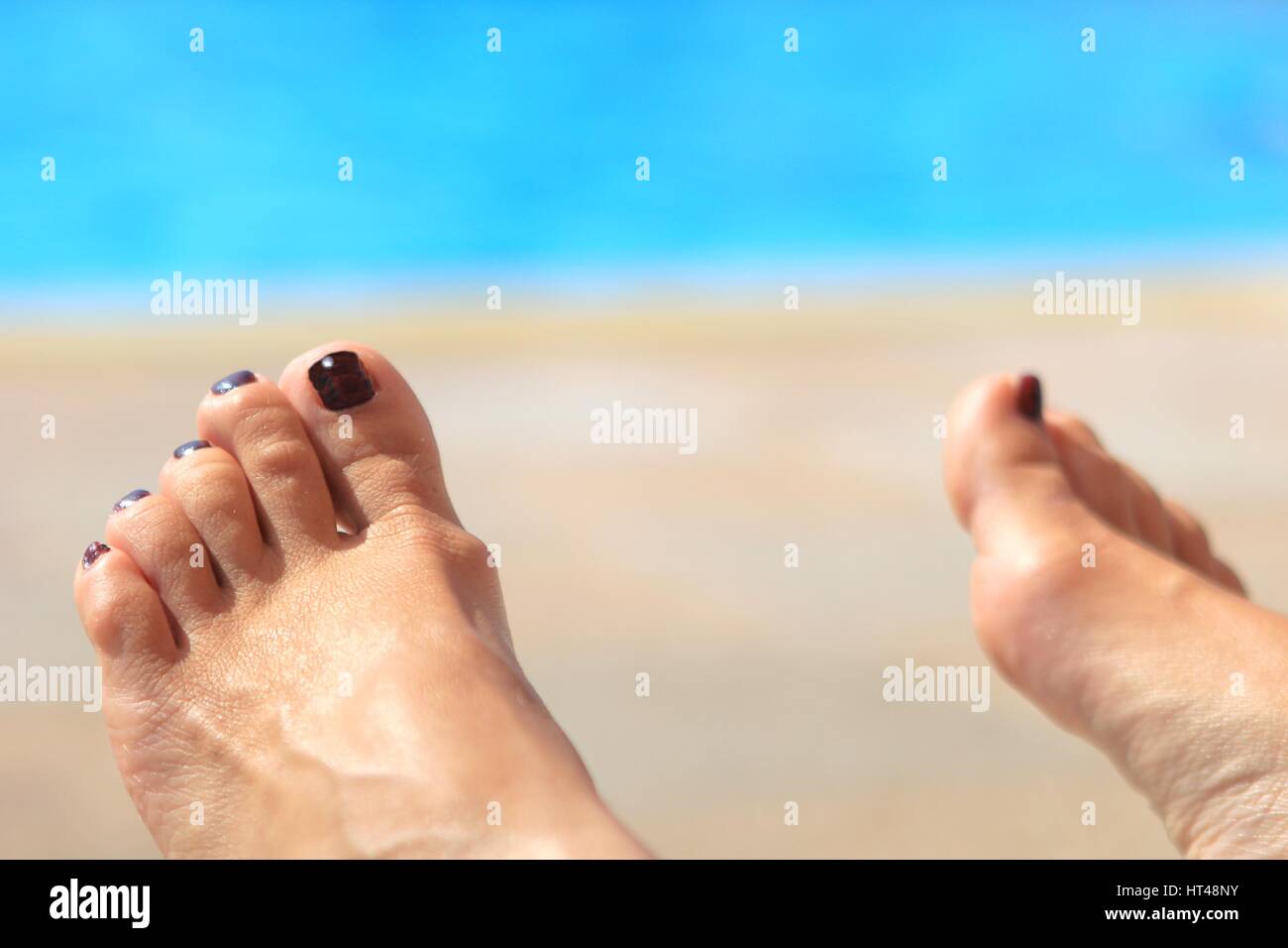 Frau die Füße mit unscharfen sonnigen Pool im Hintergrund Stockfoto