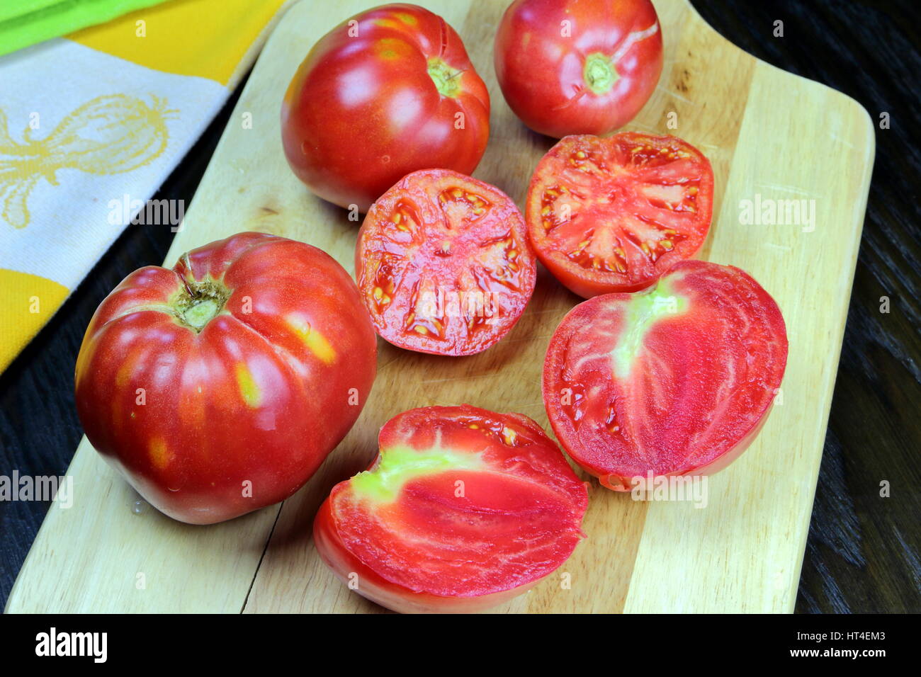 Schneiden Sie Bio grüne und rote Tomaten - GVO-Lebensmittel aus einem kultivierten Feld in der Toskana, Italien - Studio Foto-Shooting auf einem Holzbrett gefangen Stockfoto