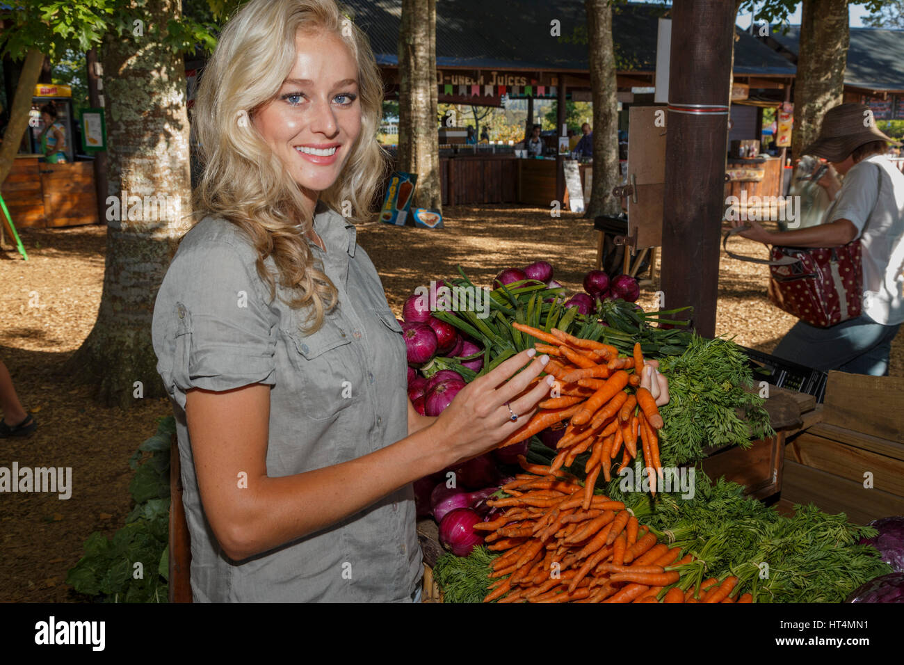 Eine junge langhaarige blonde Frau frische gesunde und nährende Produkt auf dem Markt zu kaufen. Stockfoto