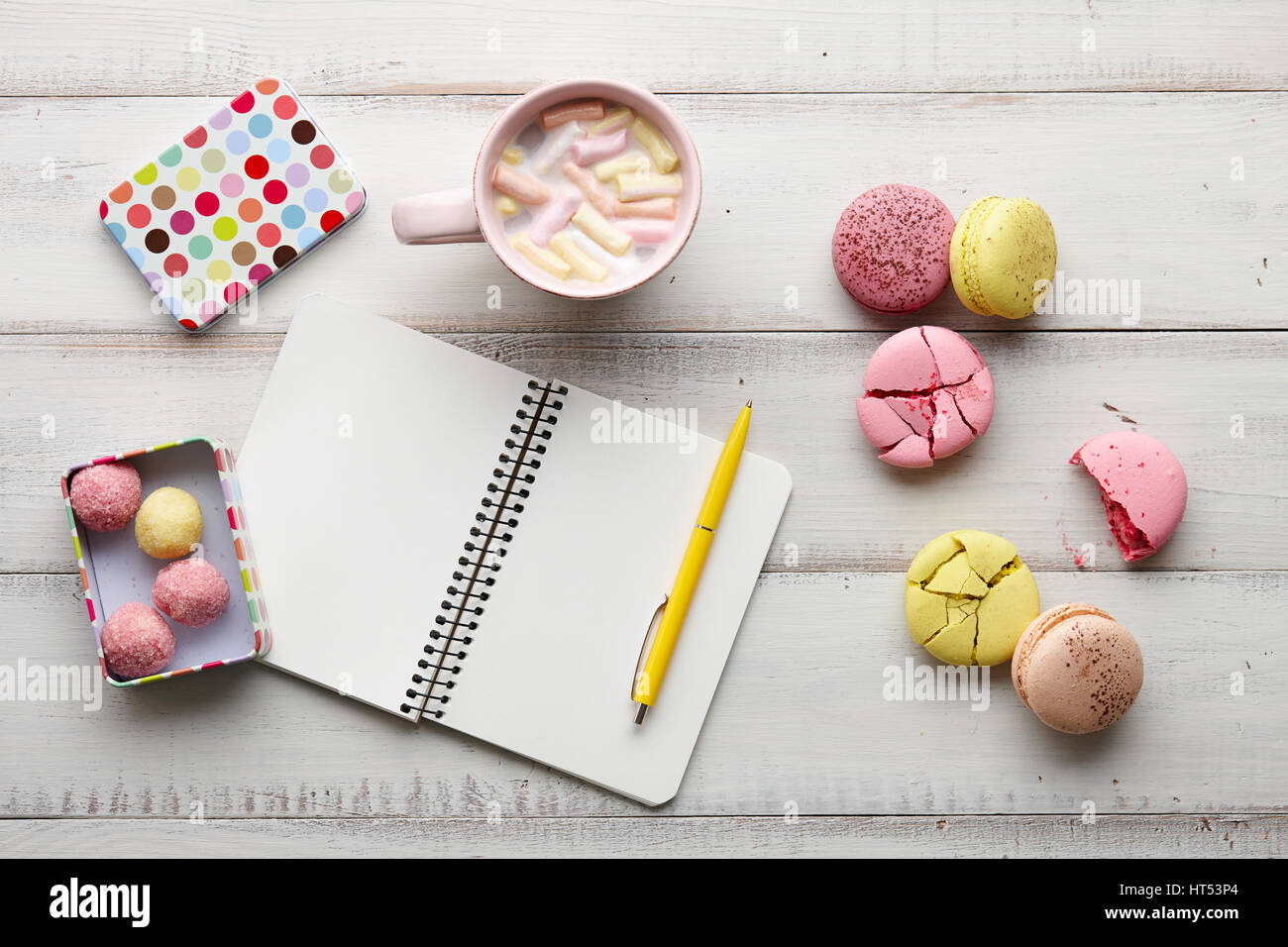 Heiße Schokolade, Süßigkeiten und Copybook auf Holztisch Stockfoto