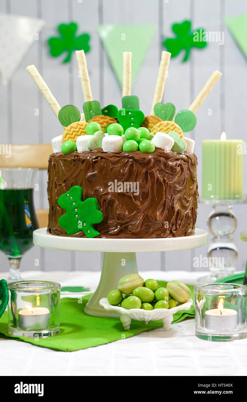 Glücklich St. Patricks Day, März 17, grün-weiße Party Tisch mit Showstopper Schokolade Kuchen mit Süßigkeiten, Kekse und Shamrock Flaggen geschmückt. Stockfoto