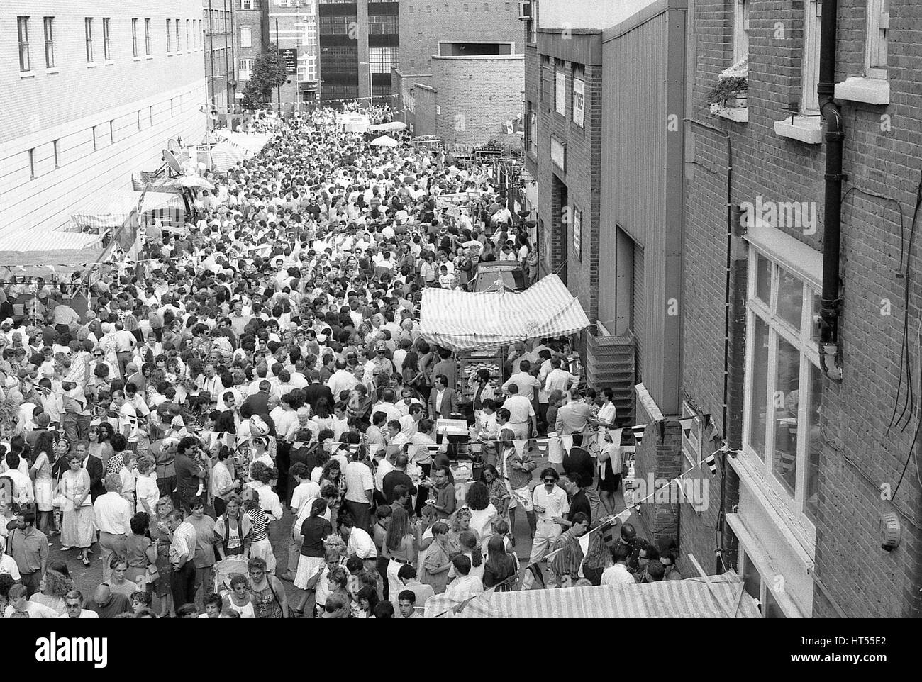 Massen von Menschen beteiligen sich die jährliche Italienisch Street Party am Warner Street in Clerkenwell, London am 21. Juli 1990. Die Partei folgt der religiösen Prozession von St.Mary Carmel in traditionell italienisches Viertel von London war. Stockfoto