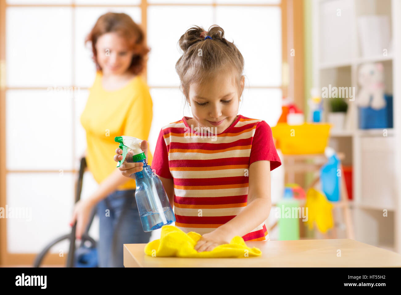 Kind Mädchen und Mutter machen Reinigung im Zimmer zu Hause Stockfoto