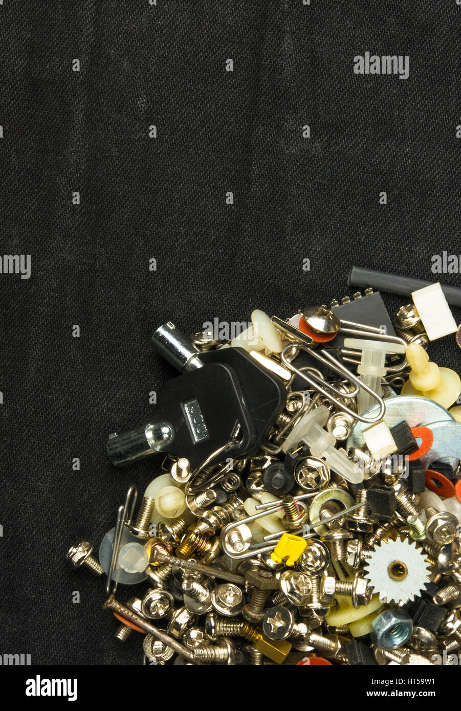 Techno-Hintergründe - verschiedene Schrauben, Schrauben, Unterlegscheiben, Muttern und andere Computer kleine Verbindungselemente auf schwarzem Stoff Stockfoto