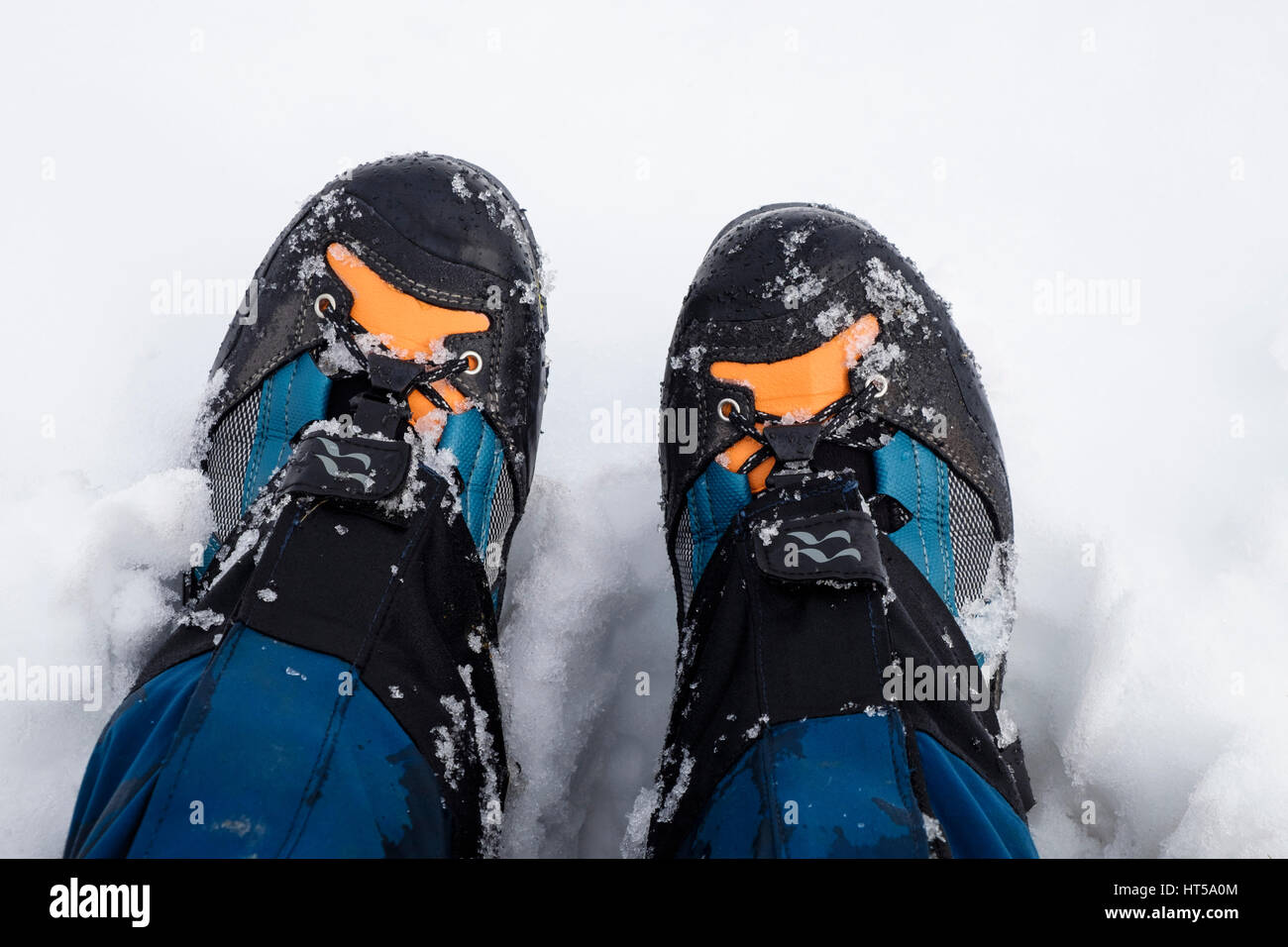 Nahaufnahme von einem Wanderer Beine tragen von einem Paar aus Stoff und Leder Wanderschuhe und Gamaschen im Schnee von oben gesehen. UK, Großbritannien. Stockfoto
