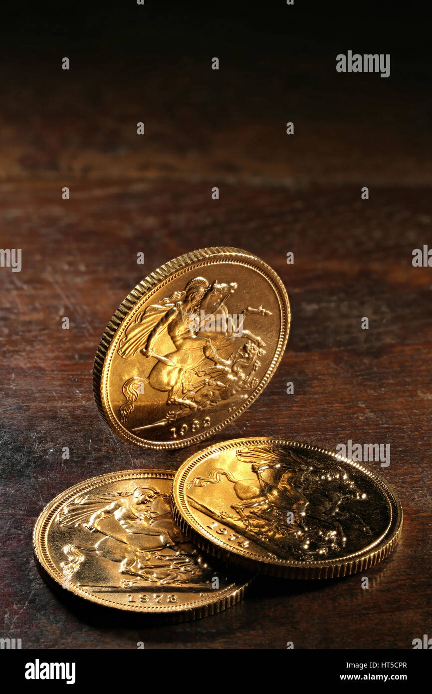 Britische Sovereign gold Münzen auf rustikalen hölzernen Hintergrund Stockfoto