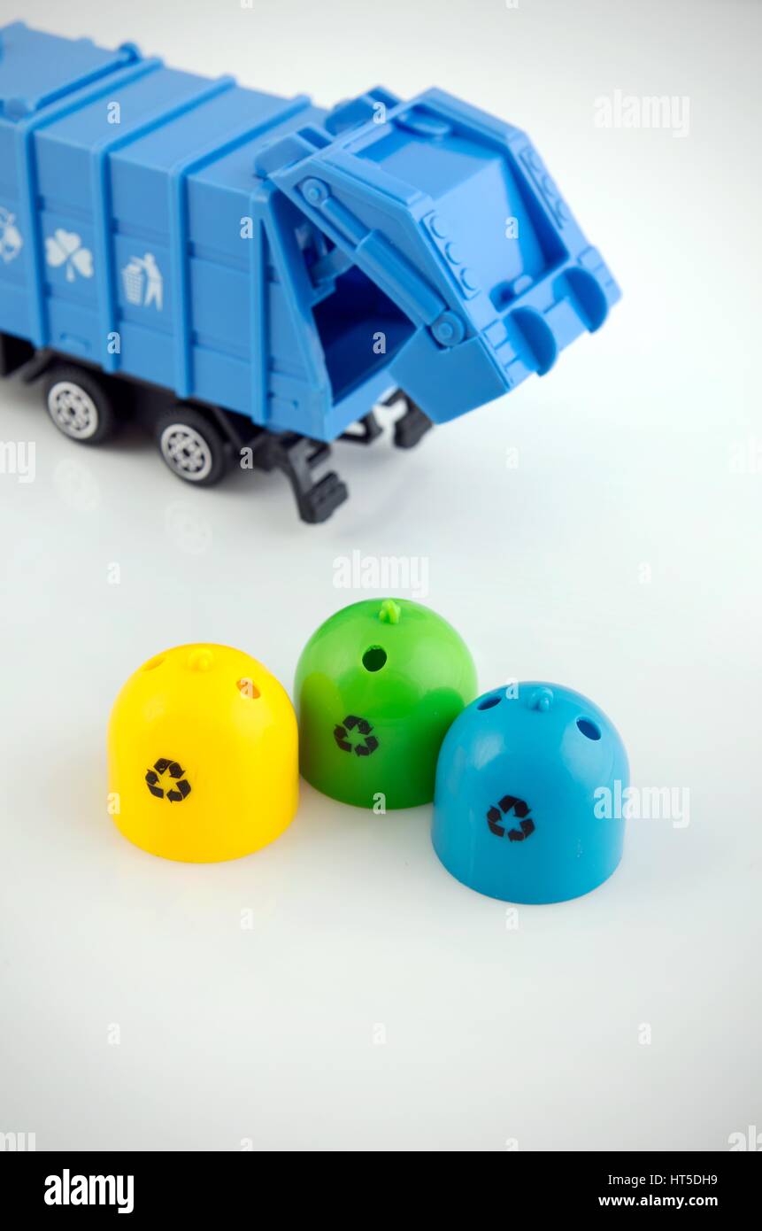 Farbige Mülltonnen und Spielzeug Müllwagen auf weißem Hintergrund Stockfoto