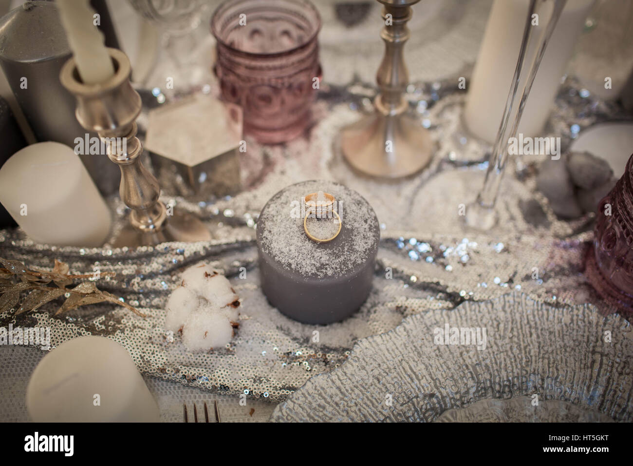 Trauringe auf eine Kerze. Dekorationen, bestreut mit Schnee. Hochzeit Urlaub. Stockfoto