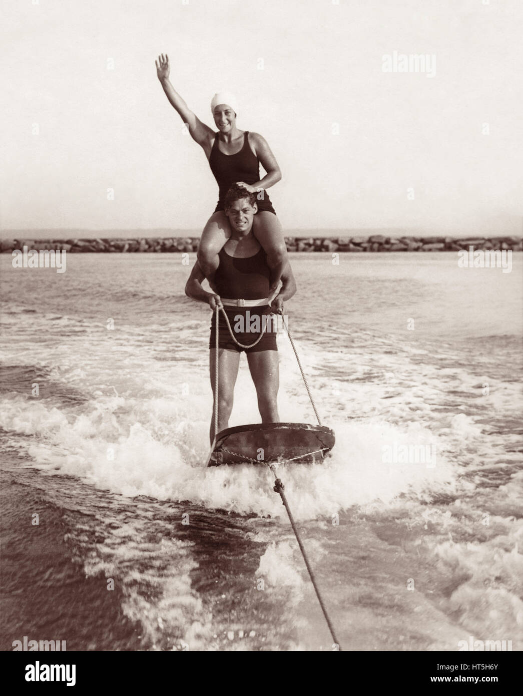 Olympiasieger Johnny Weissmüller (Tarzan) und Helen Meany aquaplaning hinter einem Motorboot im Long Island Sound in der Nähe von Rye Beach in New York im Jahre 1929. Stockfoto