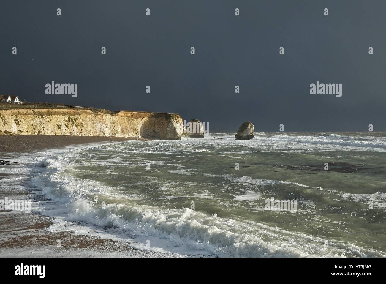 Freshwater Bay, Isle Of Wight mit dunklen Gewitterhimmel aber warmen Abendlicht auf dem Meer Stockfoto