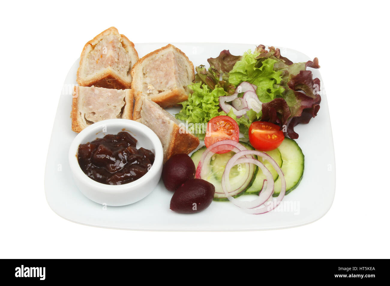 Pork Pie, Gurke und Salat auf einem Teller isoliert gegen weiß Stockfoto