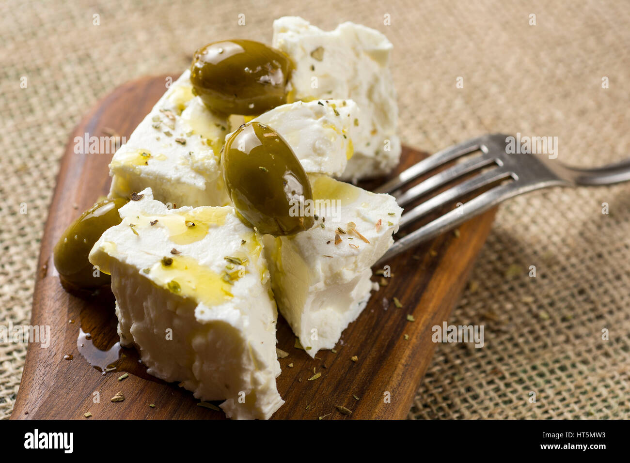 Griechischer Feta-Käse mit grünen Oliven, Oregano und Olivenöl Stockfoto
