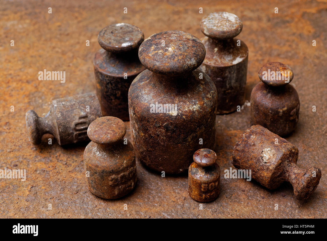 Hintergründe und Texturen: Gruppe von sehr alt und rostig Gewichte bei den Waagen auf rostige Oberfläche angeordnet. Stockfoto