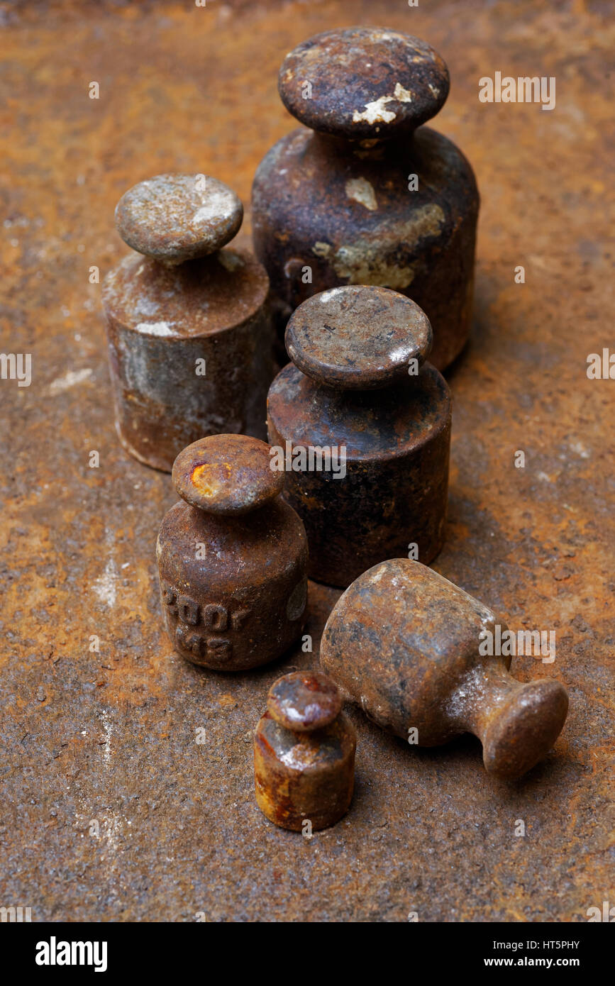 Hintergründe und Texturen: Gruppe von sehr alt und rostig Gewichte bei den Waagen auf rostige Oberfläche angeordnet. Stockfoto