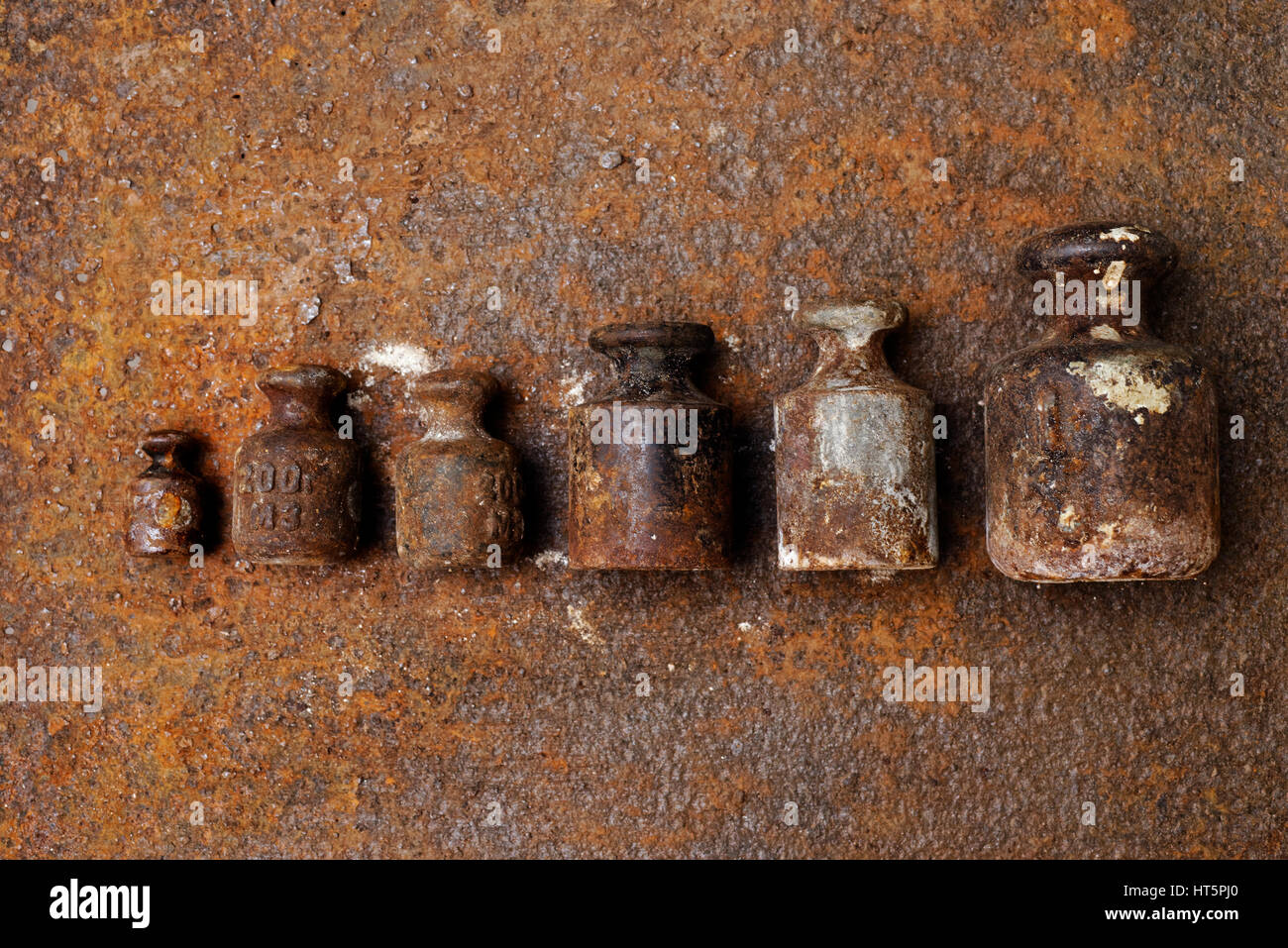 Hintergründe und Texturen: Gruppe von sehr alt und rostig Gewichte bei den Waagen auf rostige Oberfläche angeordnet. Stockfoto