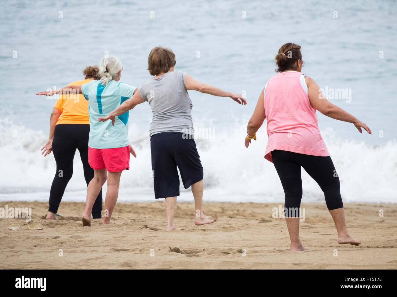Ältere Frauen am Strand täglich Dehnung halten Passungsklasse in Spanien Stockfoto