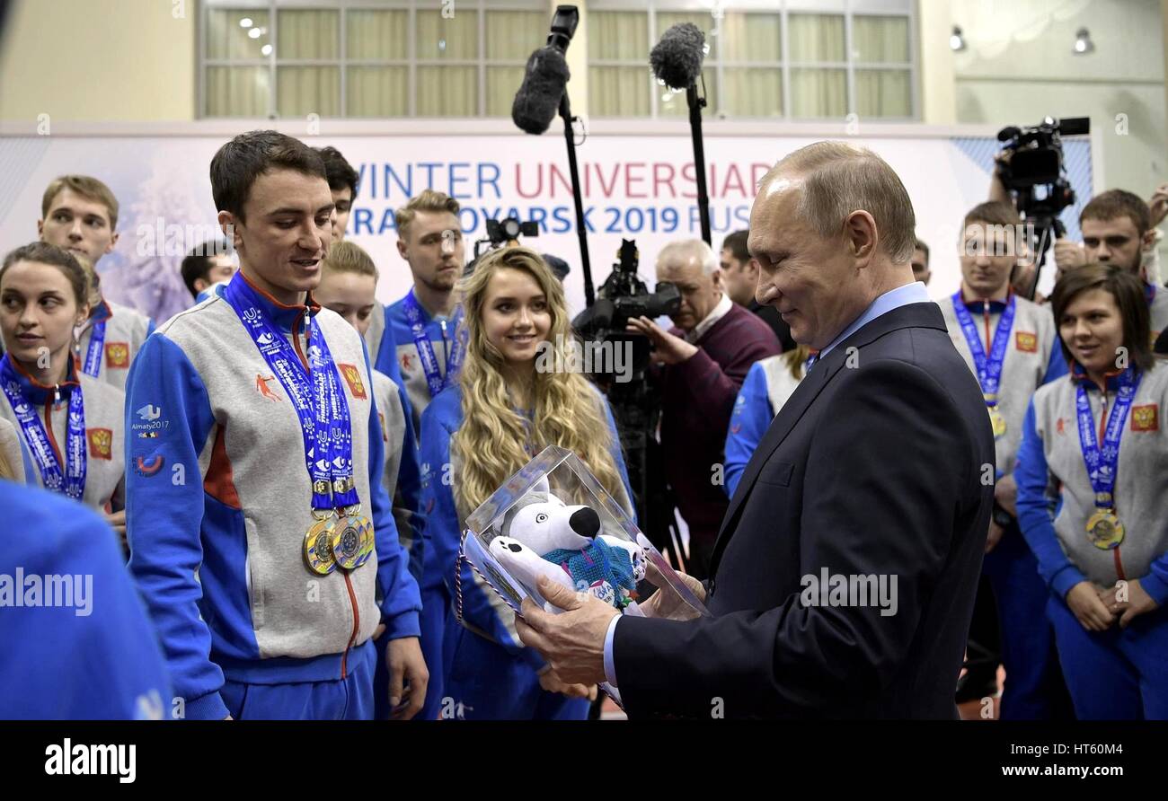 Der russische Präsident Vladimir Putin wird ein Maskottchen Souvenir da trifft er mit Athleten, die in der letzten Winter-Universiade während eines Besuchs in der Akademie Biathlonis 1. März 2017 in Krasnojarsk, Russland Medaillen. Stockfoto