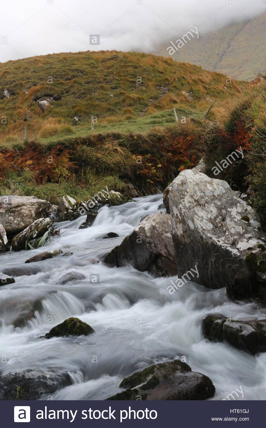 Ein Stream, hetzen, um den Atlantischen Ozean bei Brandon Creek, County Kerry, Irland Stockfoto