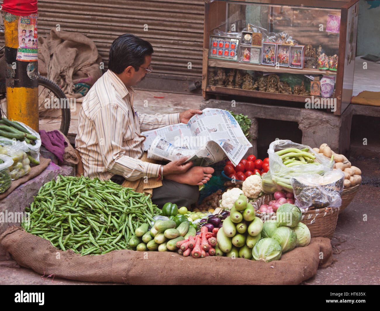 Gemüse Verkäufer eine Pause, um sich mit aktuellen Themen in seinem Vortrag im Bereich Chandni Chowk von Alt-Delhi, Indien Stockfoto