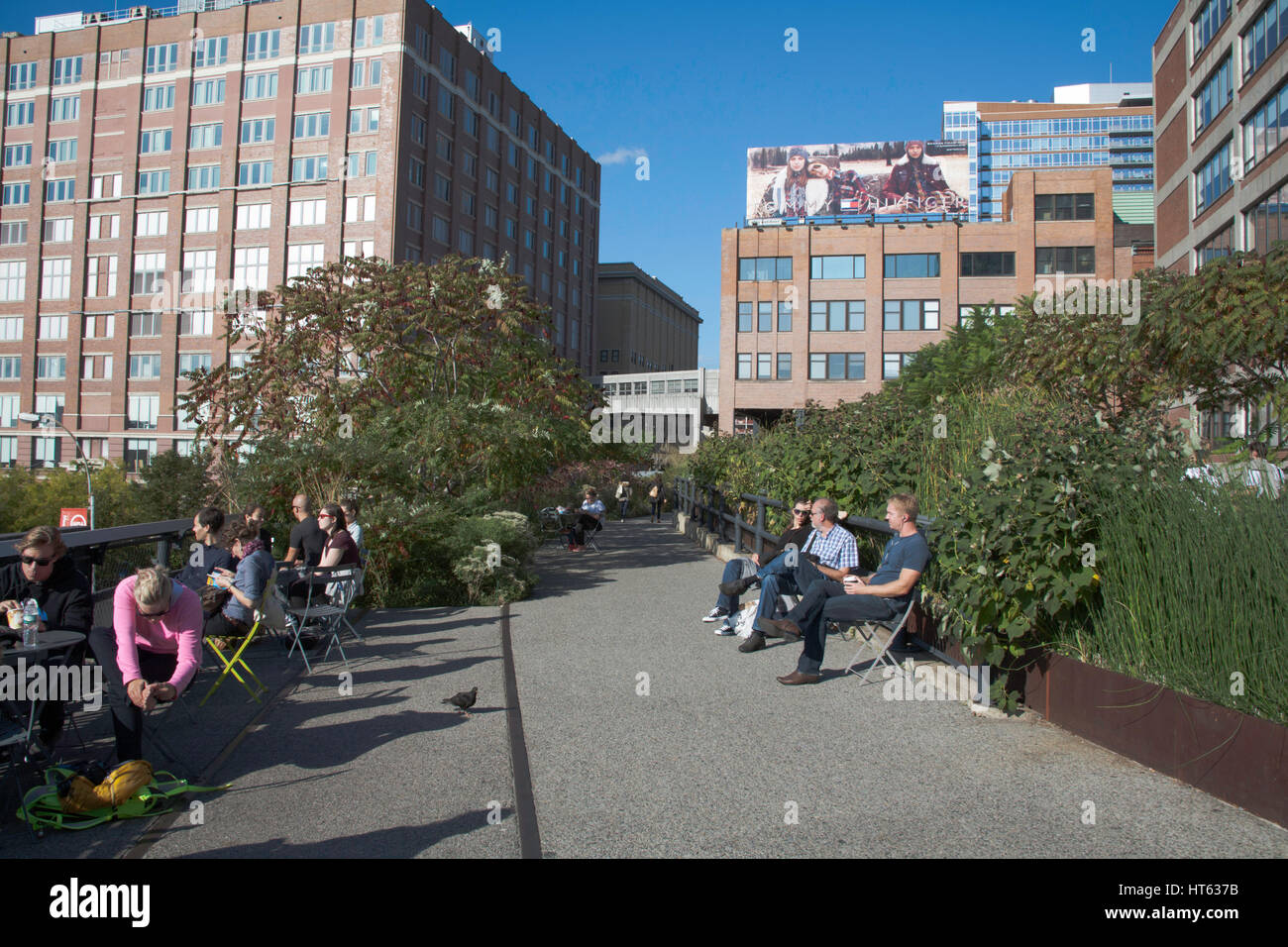 Menschen sitzen oder bei einem Spaziergang entlang der Hochspannungsleitung auf einen angenehmen Herbst Nachmittag zwischen The Meatpacking District und ChelseaNew York City USA Stockfoto