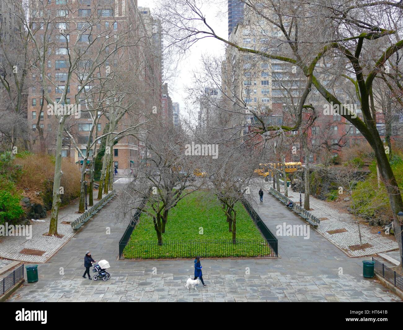 Spaziergang mit dem Hund und schob einen Kinderwagen in Carl Schurz Park im Spätwinter an einem regnerischen Tag. New York, New York, USA. Stockfoto