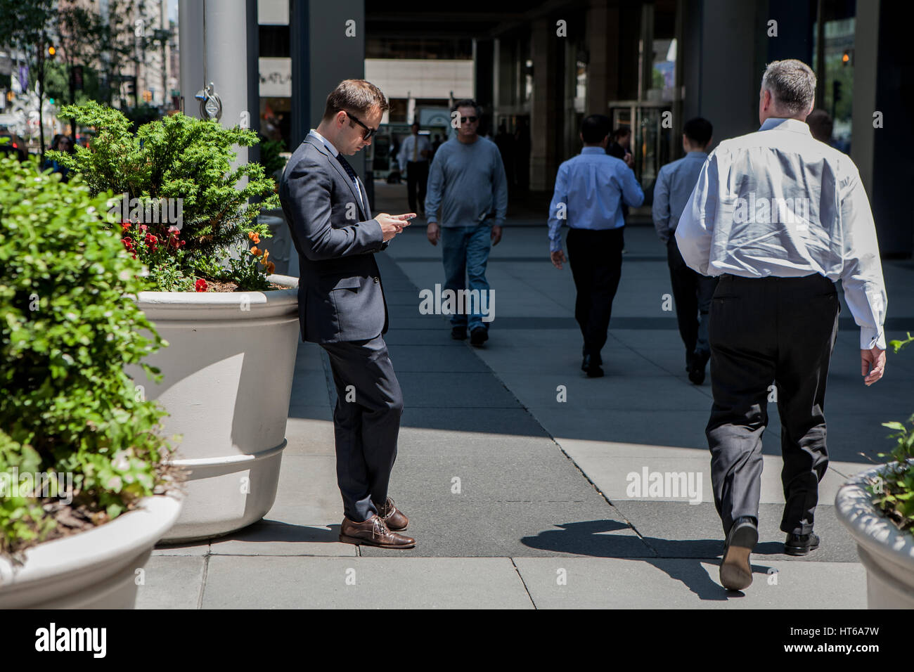 Ein Business-Mann ist auf seinem Telefon irgendwo in New York City, Vereinigte Staaten von Amerika. Stockfoto