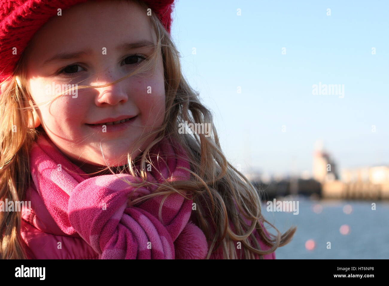 Nahaufnahme Bild windswept Mädchen an einem windigen Tag, Kindheit Konzept, winter Konzept, kalter Wind, Wetter Howth Irland, Gesicht rote Wangen windigen Tag gespült Stockfoto