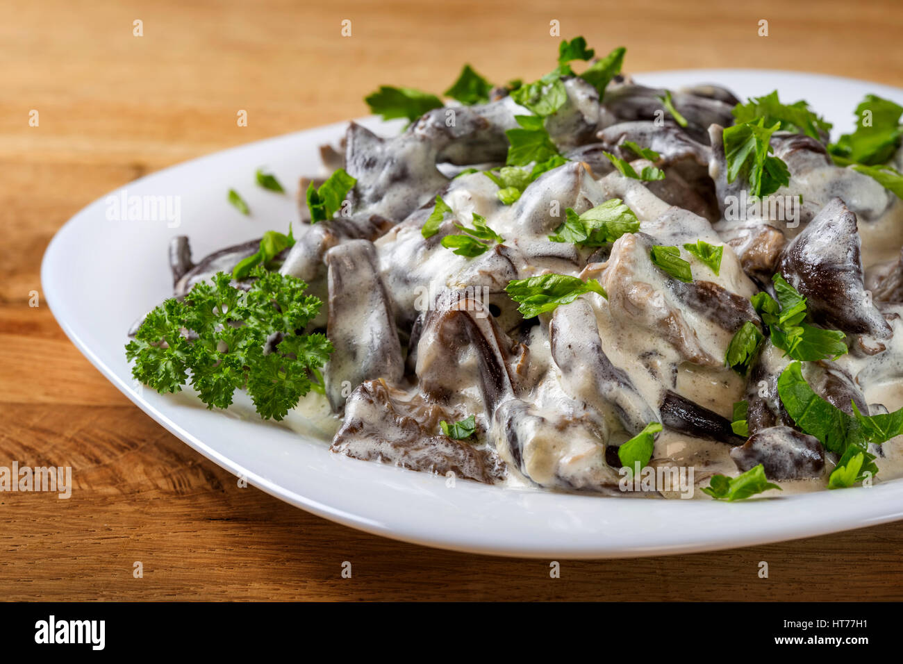 Rumänische Lebensmittel - Pilze mit Sauerrahm und Petersilie auf Platte Stockfoto
