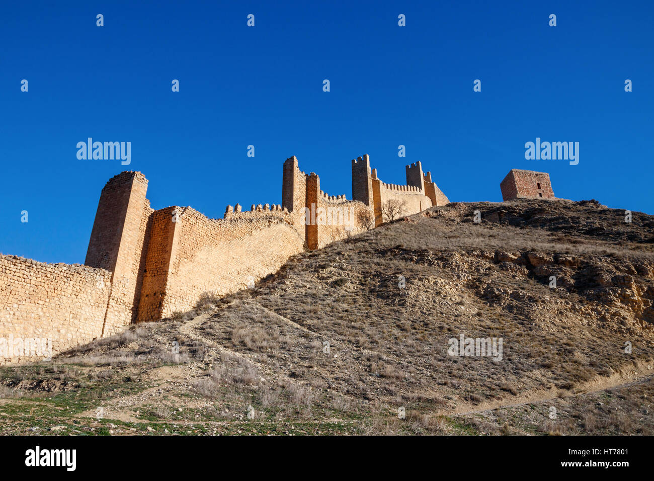 Hügel mit Stadtmauer und Türmen unter blauem Himmel. ALBARRACIN, Teruel, Spanien. Stockfoto