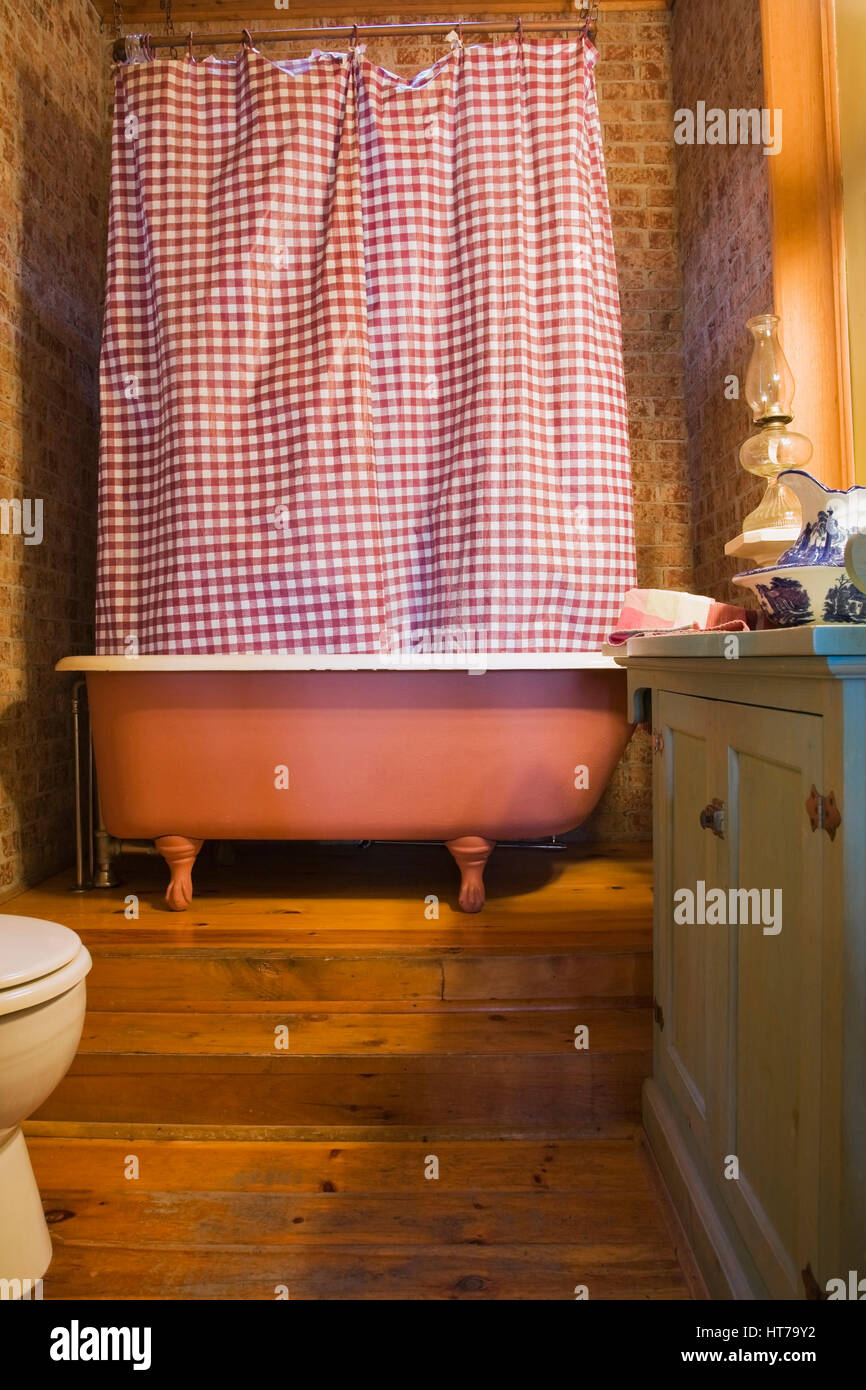 Badezimmer mit frei stehender Badewanne und rot weiss kariert Dusche 1904 viktorianischen Haus innere Vorhang. Stockfoto