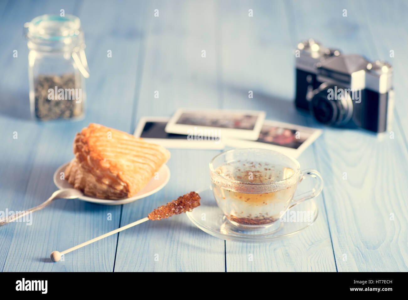 Ein Glastasse frischen heißen schwarzen Tee auf dem Tisch. Französische Kuchen im Hintergrund. Stockfoto