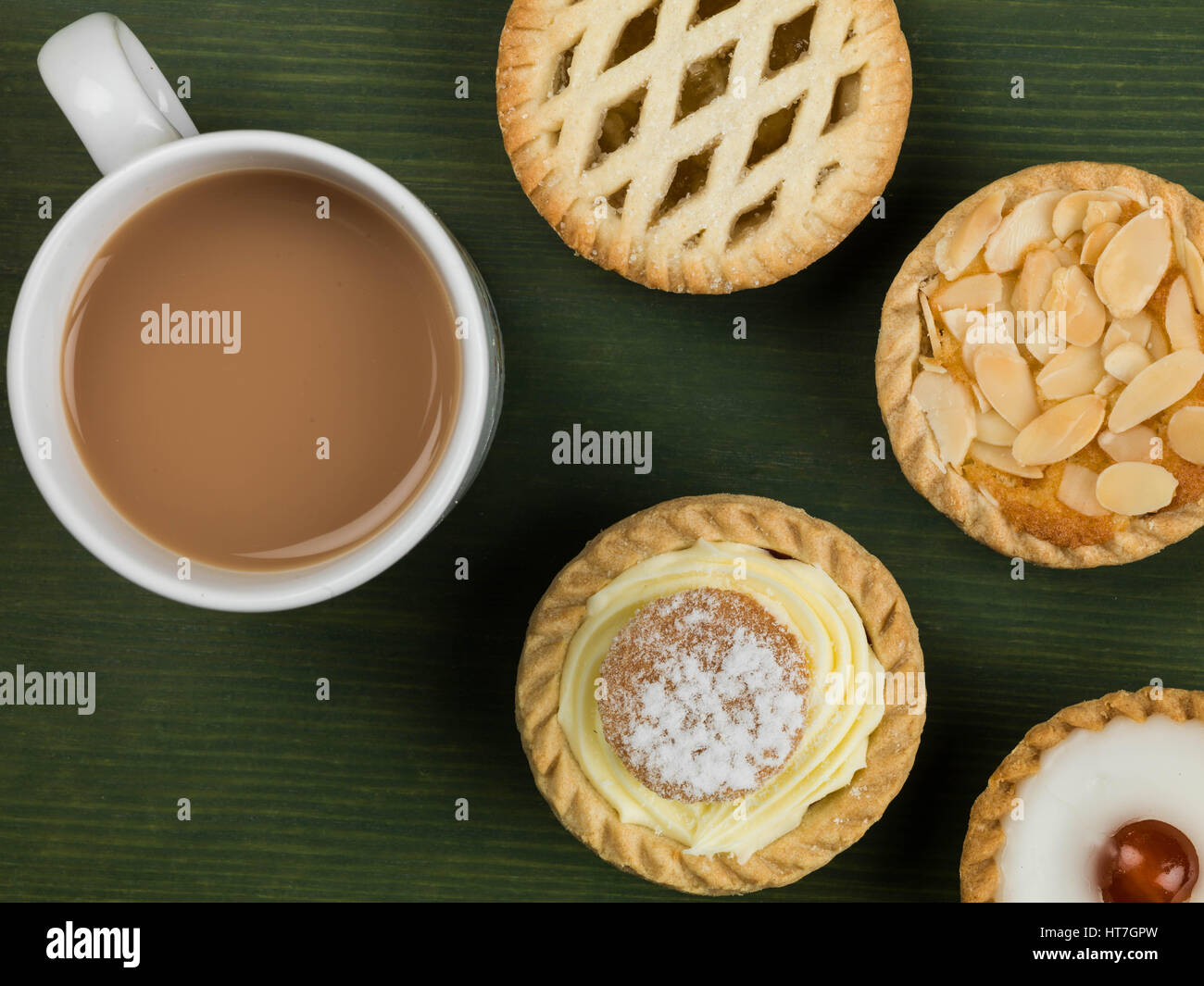 Auswahl von individuellen Torten oder Kuchen mit einer Tasse Kaffee vor einem grünen Hintergrund Stockfoto
