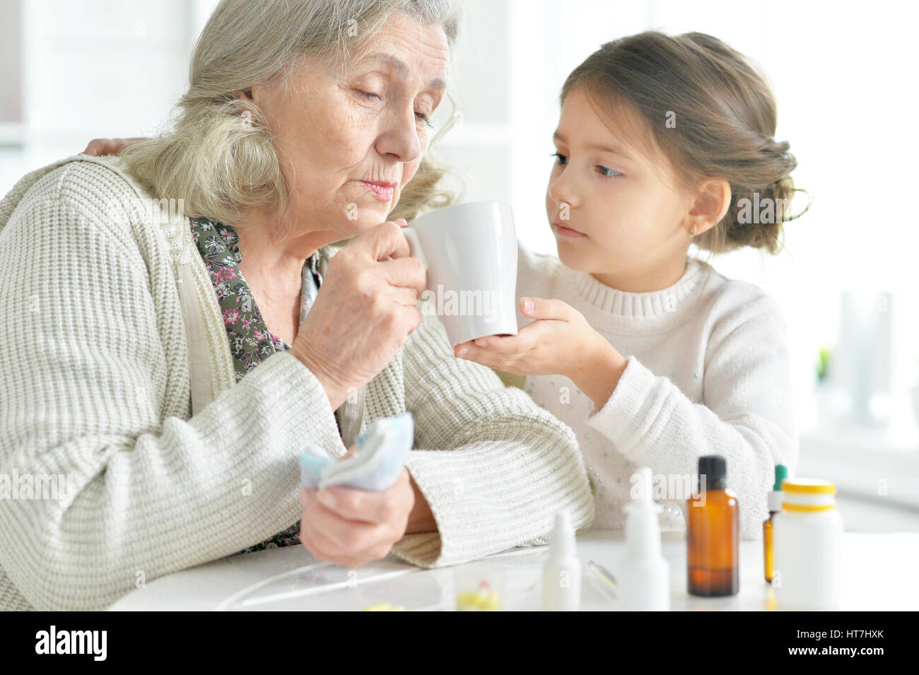 Enkelin kümmert sich eine kranke Großmutter Stockfoto