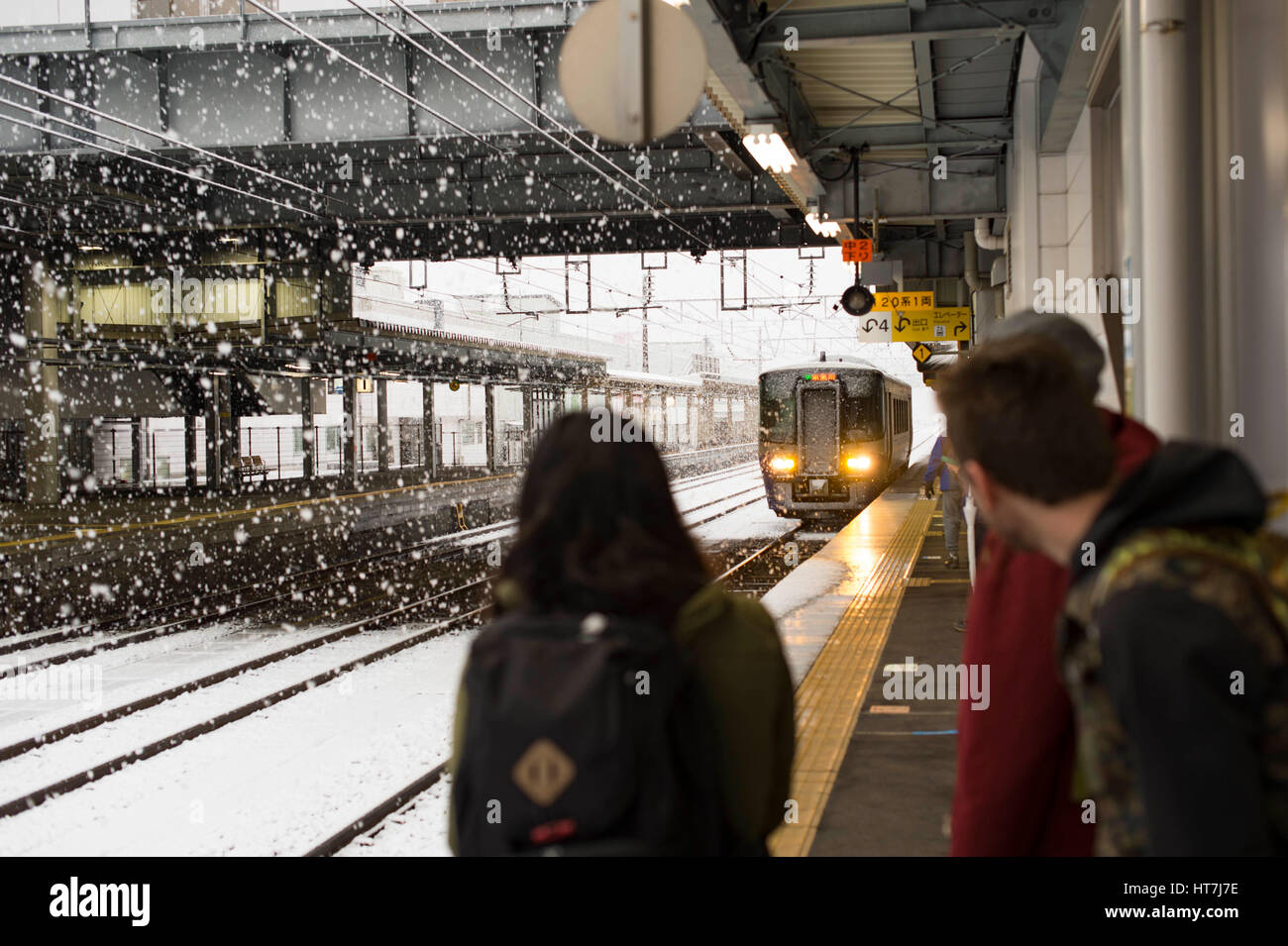 Snowboarder wartet Zug an der Station während A Schnee Sturm in der Nähe von Tokio, Japan Stockfoto