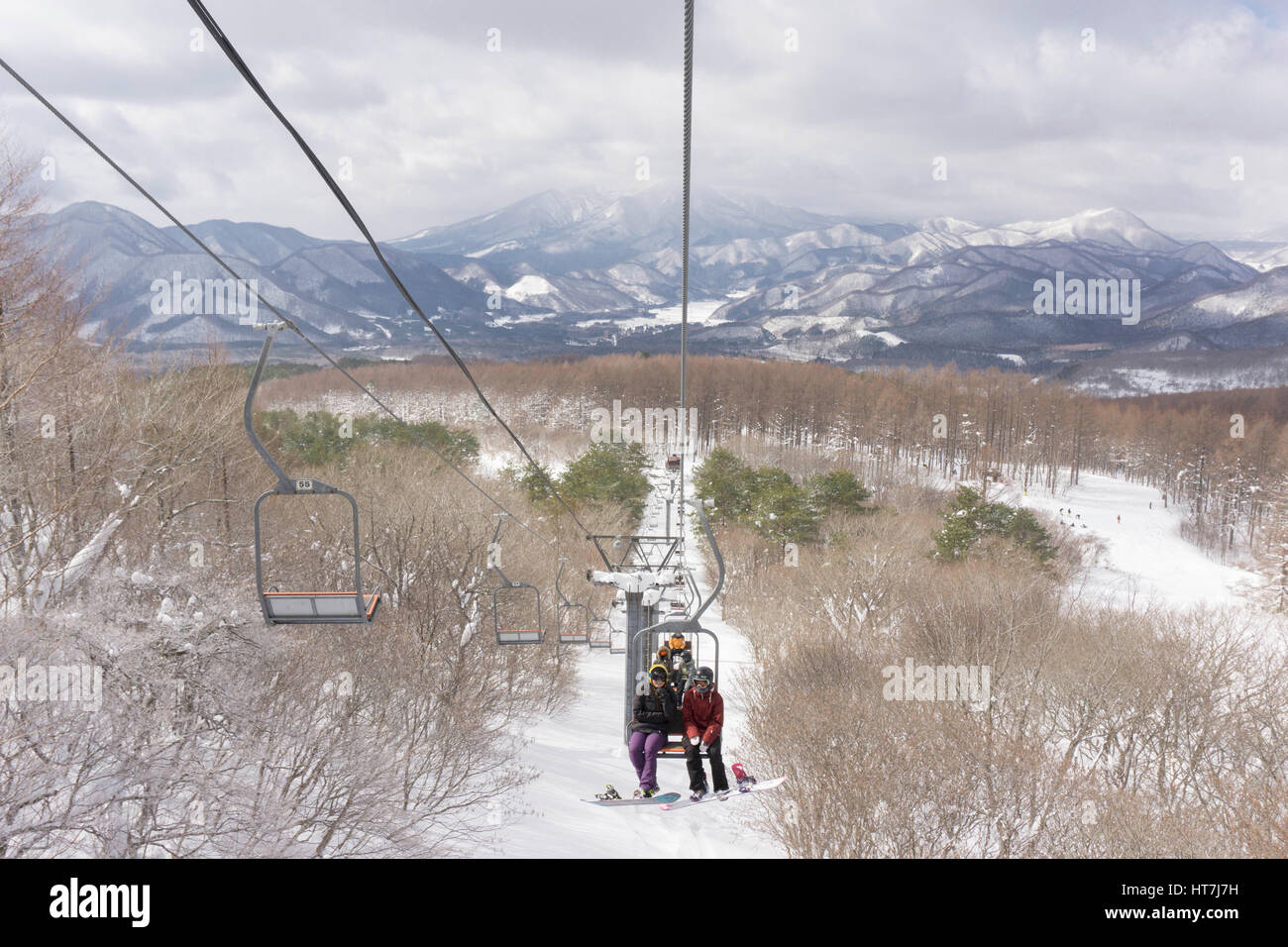 Snowboarder am Sessellift am kleinen Ski-Hügel In Japan fahren Stockfoto