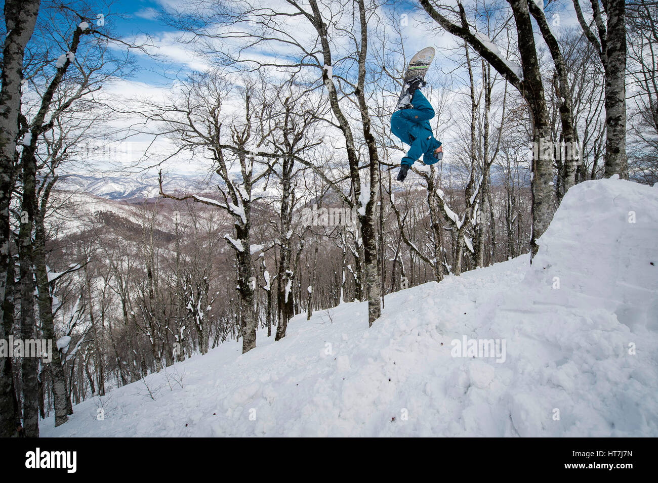 Snowboarder macht einen Backflip im Hinterland In Japan Stockfoto
