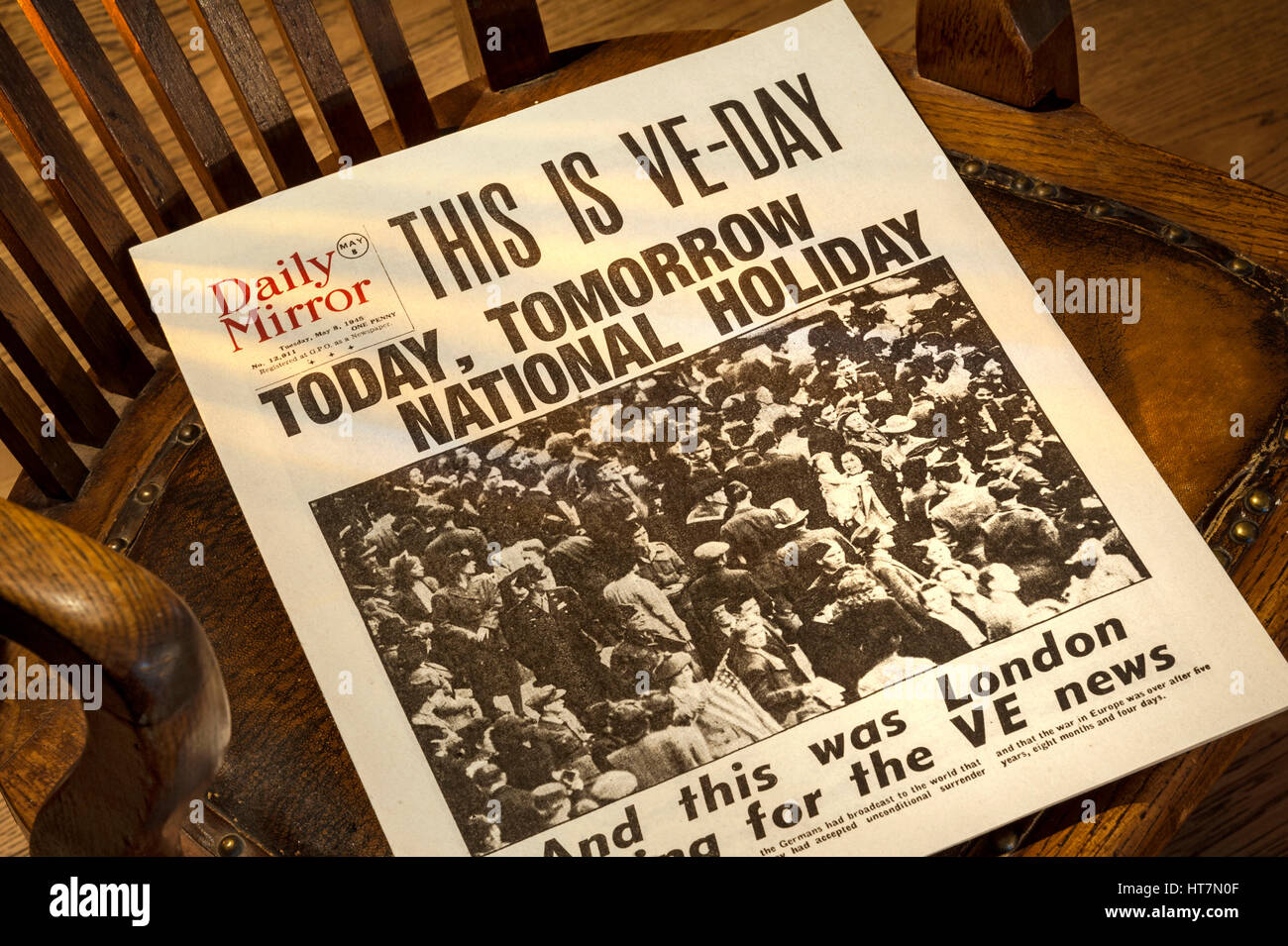 VE TAG GROSSBRITANNIEN SCHLAGZEILEN historische Daily Mirror Zeitung Schlagzeile "Dies ist VE Day" vom 8. Mai 1945 auf 1940 Holzstuhl mit Blick Fenster Licht Stockfoto