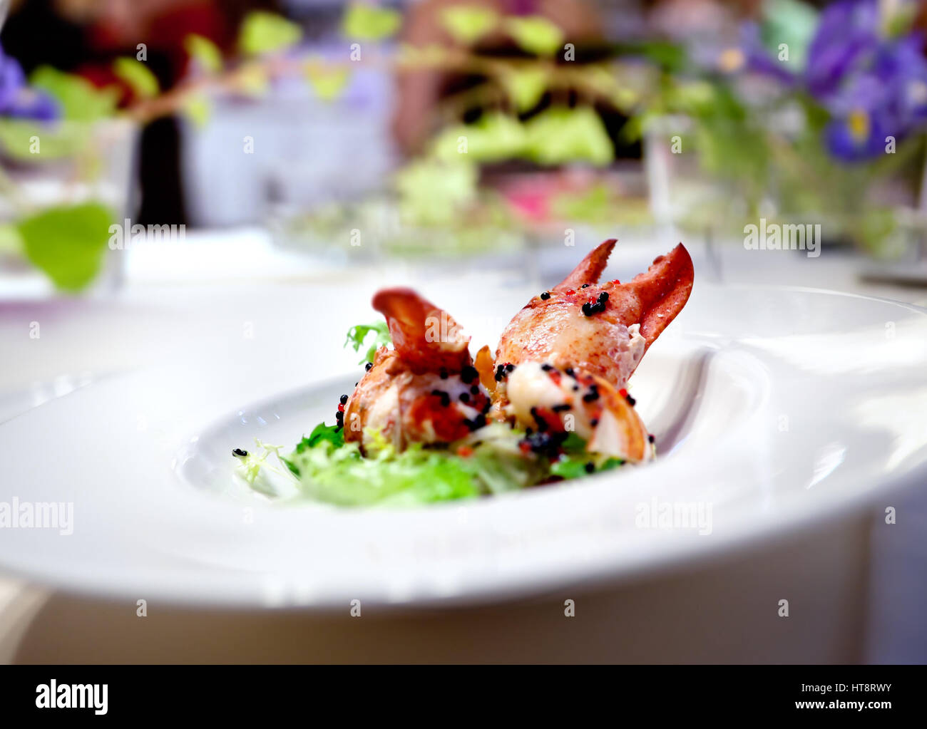 Festliches Mahl. Restaurant Hummer Gericht Blumenarrangement. Moderne Küche für Feierlichkeiten Stockfoto