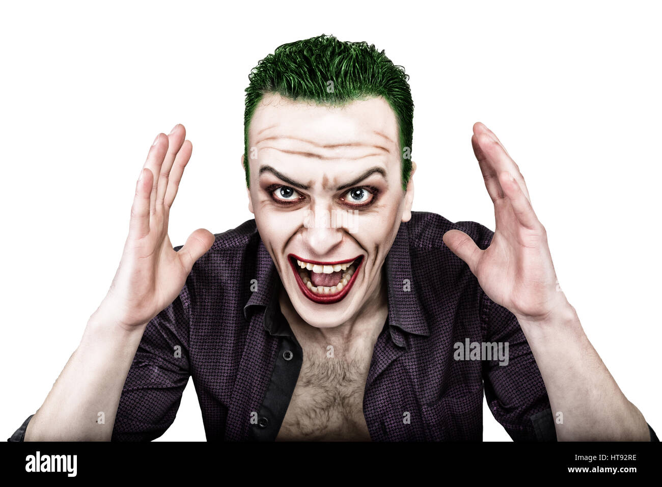 Kerl mit verrückten Joker Gesicht, grüne Haare und idiotische Smike. Karneval Kostüm. Stockfoto