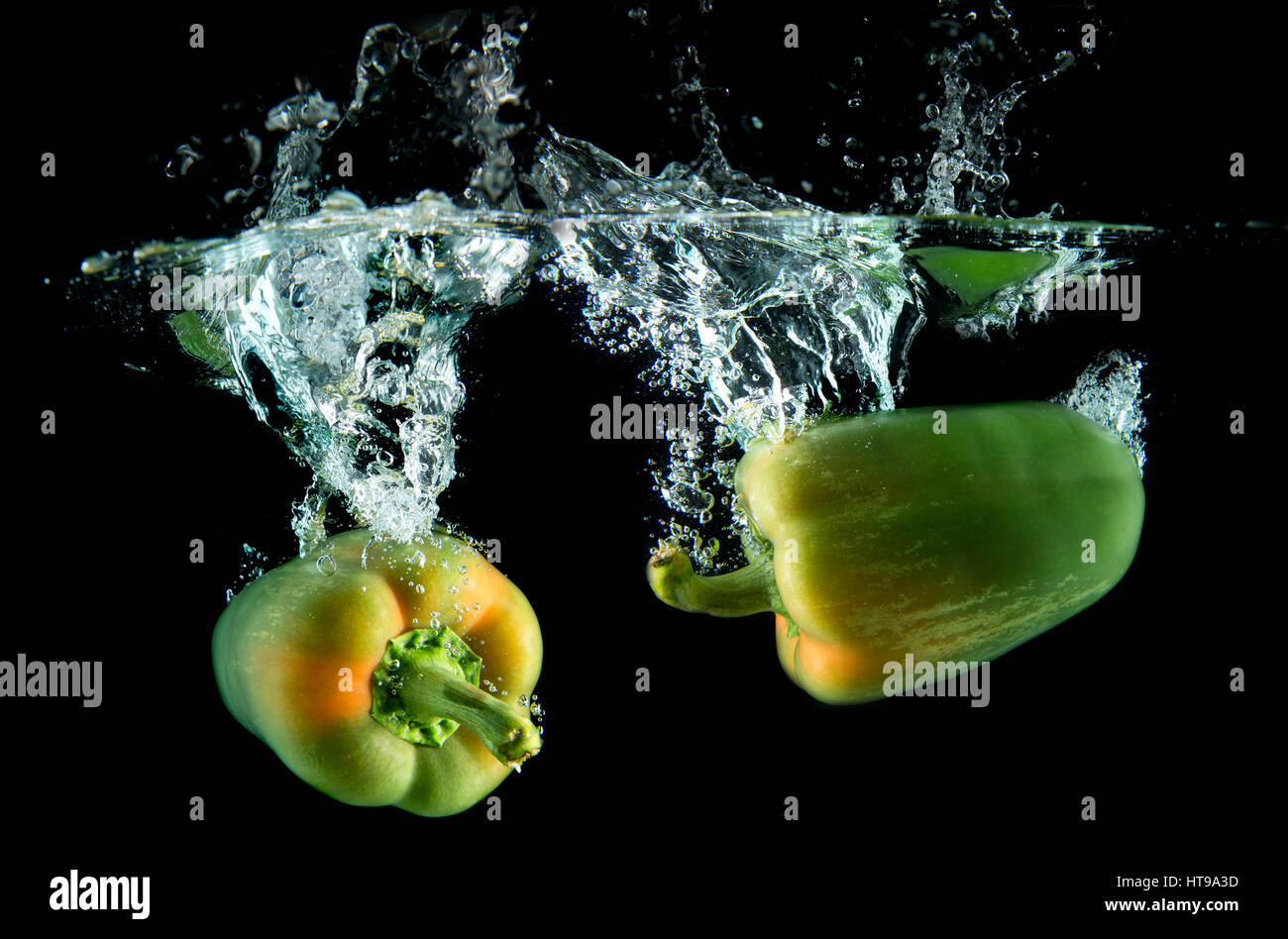 Spritzwasser aus Wasser Droping Paprika in Studio-Beleuchtung auf schwarzem Hintergrund. Stockfoto