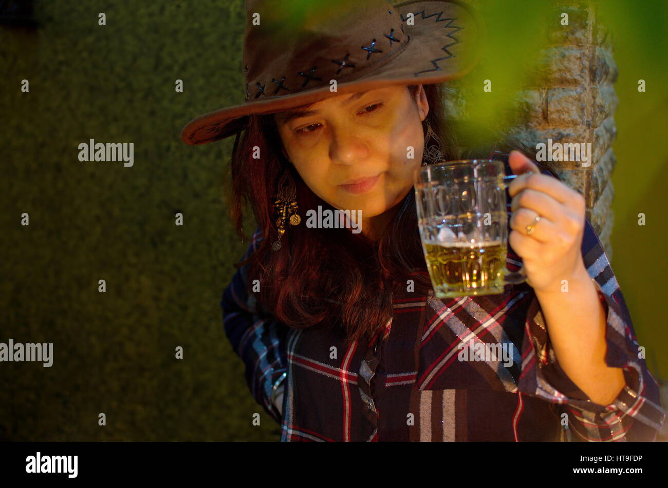 Dame in braunen Hut Bier trinken Stockfoto