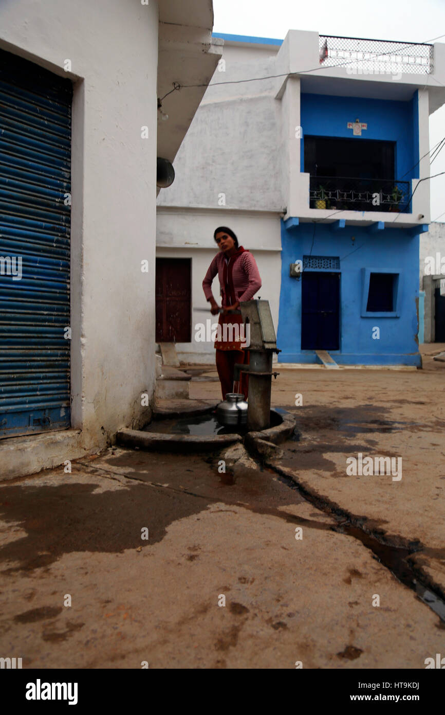 Unbekannte indische Frau in nehmen Sie Wasser aus dem öffentlichen Brunnen. Stockfoto