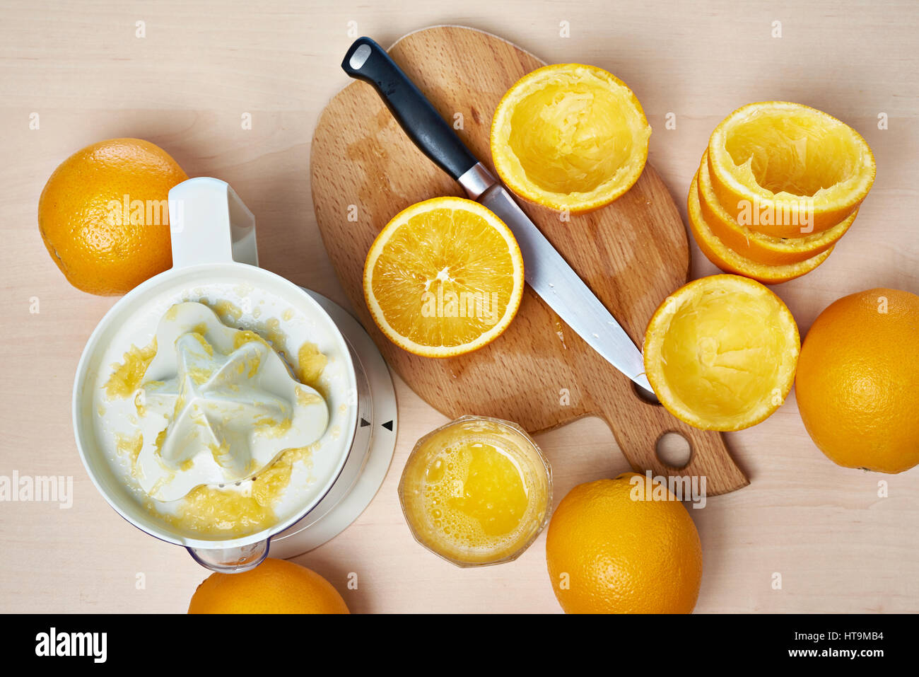 Saftpresse, Messer und Orangen auf ein Schneidebrett Stockfoto