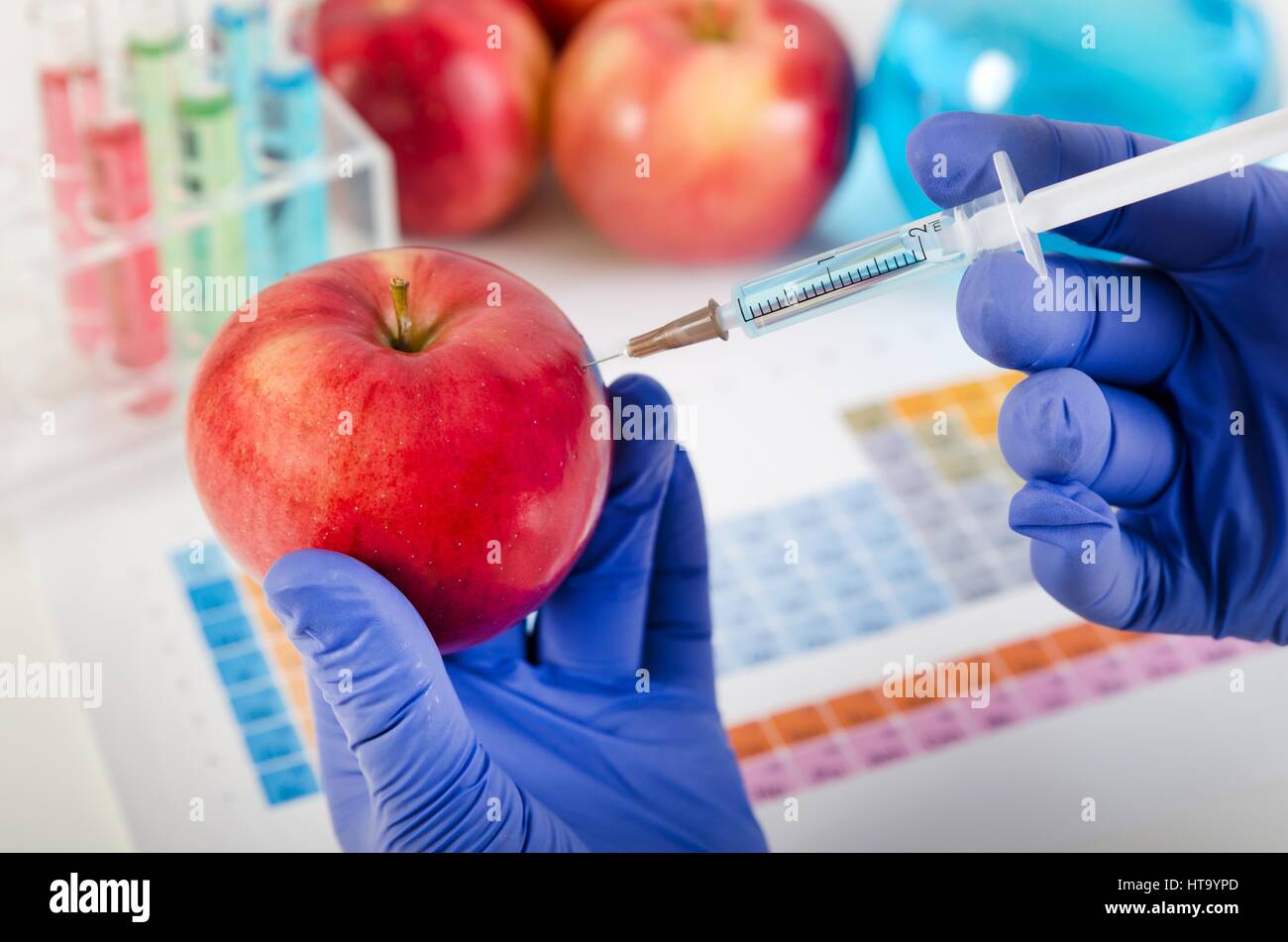 Analyst spritzt Flüssigkeit in Apfel. Gentechnisch veränderte Lebensmittel in Lab Konzept. Stockfoto
