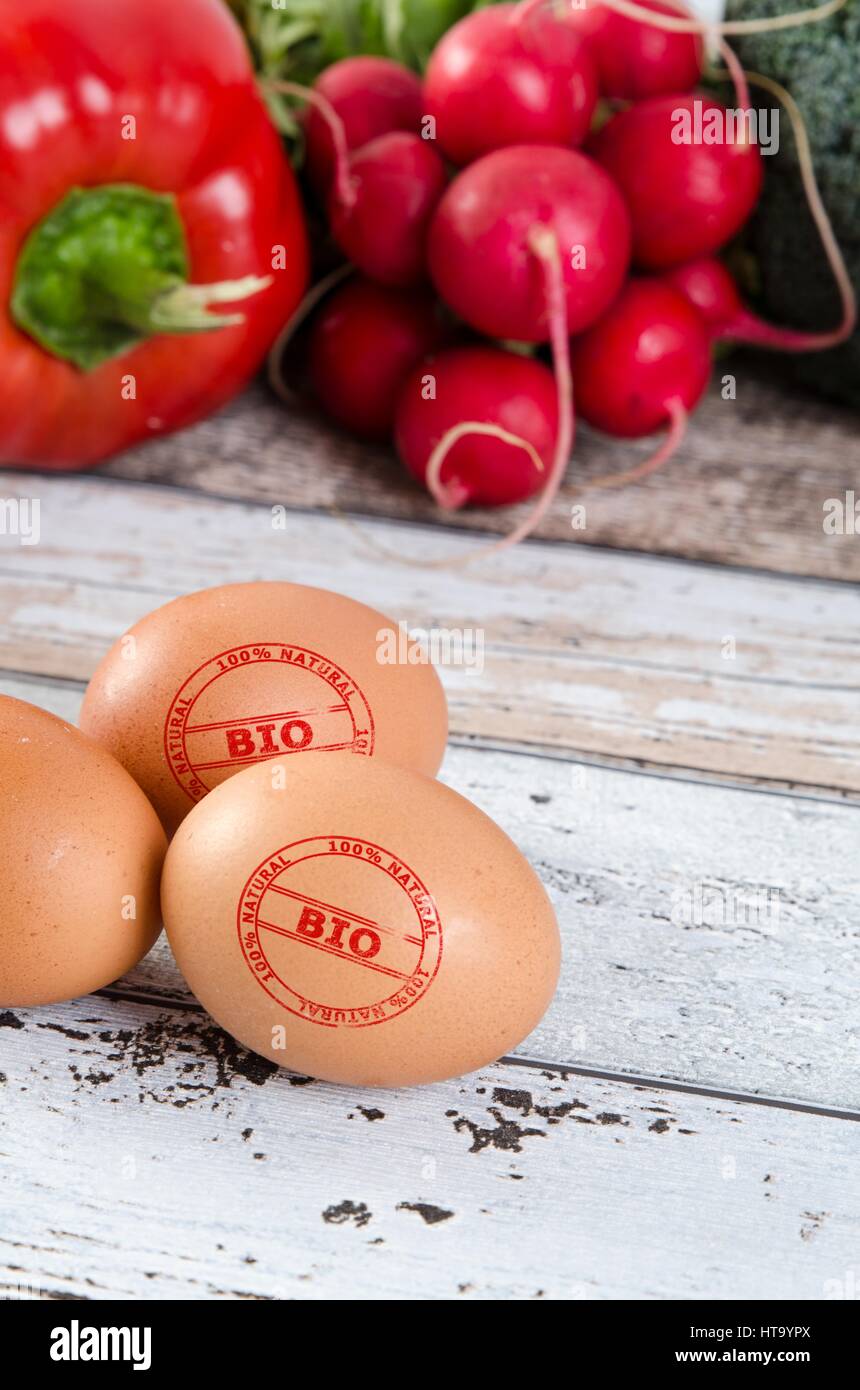 Gesunden Eizellen mit BIO-Siegel. Paprika und Radieschen im Hintergrund. Stockfoto
