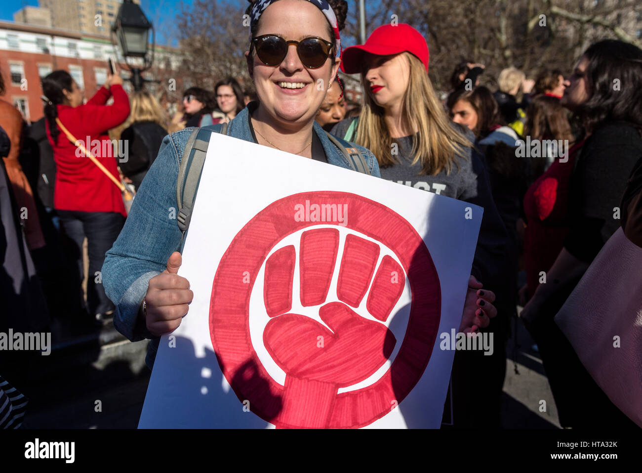 New York, USA. 8. März 2017. Frauen markiert internationaler Frauentag - A Tag ohne a Woman, mit einer Kundgebung in Washington Square Park, gefolgt von einem März. Viele Frauen trugen rote und habe den Tag als einen Generalstreik. Frau mit einem Schild mit dem Symbol für Womann Power in rot. Bildnachweis: Stacy Walsh Rosenstock/Alamy Live-Nachrichten Stockfoto