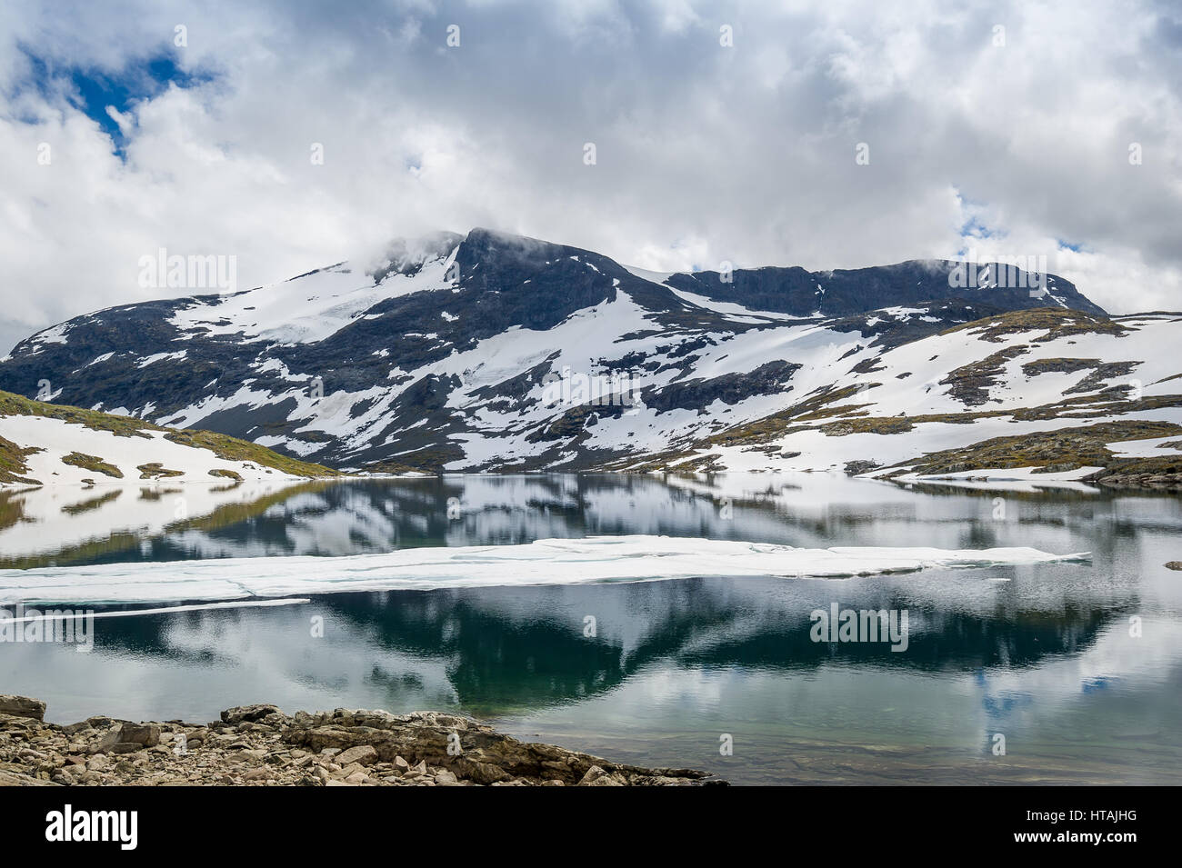 Berglandschaft mit schneebedeckten Felsen und Schmelzwasser See mit schöne Reflexion. Straße 55, National Tourist Route, Norwegen. Stockfoto