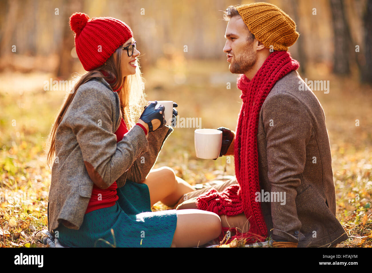 Stilvolle paar mit Teetassen sprechen im park Stockfoto