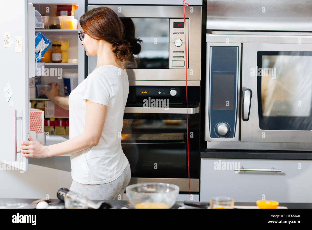 Hausfrau öffnende Tür des Kühlschranks zu Lebensmitteln Stockfoto